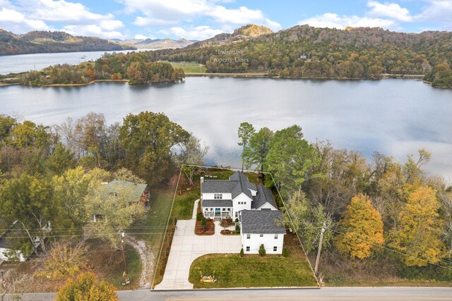 drone / aerial view with a wooded view and a water and mountain view