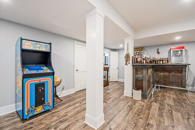 bar featuring a dry bar, baseboards, wood finished floors, and recessed lighting