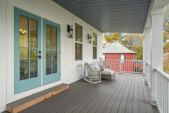 wooden terrace with a porch and french doors