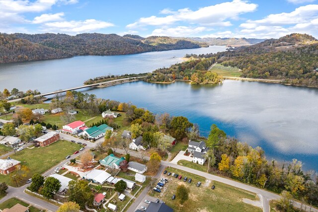 birds eye view of property featuring a water view and a view of trees