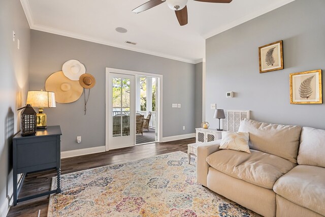 living area with ornamental molding, dark wood-style flooring, visible vents, and baseboards