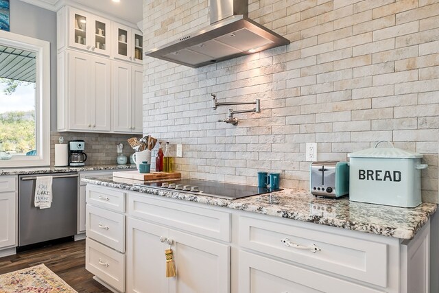 kitchen with stainless steel dishwasher, glass insert cabinets, white cabinets, wall chimney range hood, and black electric cooktop