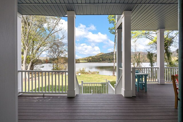 deck featuring a water view and a lawn