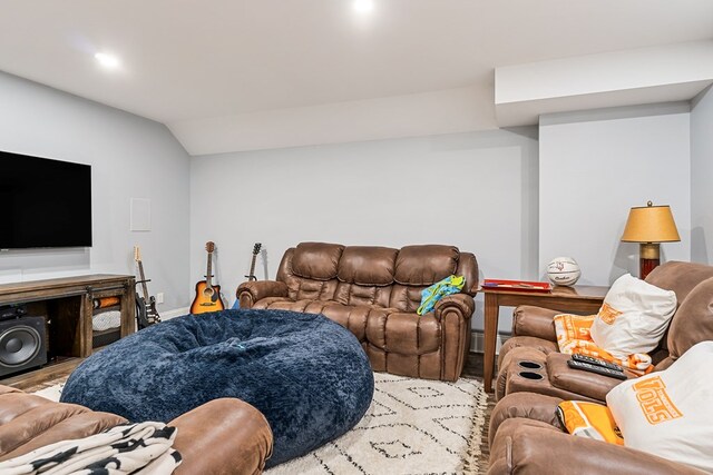 living area with lofted ceiling, baseboard heating, and wood finished floors