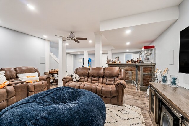 living area featuring decorative columns, a ceiling fan, light wood-style flooring, a bar, and recessed lighting