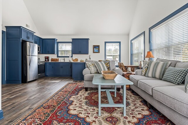 living area with dark wood-style floors, visible vents, and high vaulted ceiling