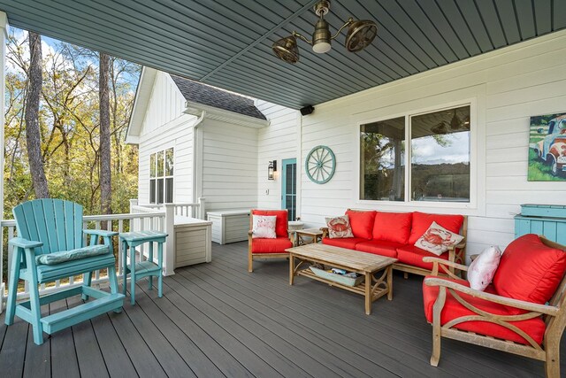 wooden terrace with an outdoor hangout area and a ceiling fan