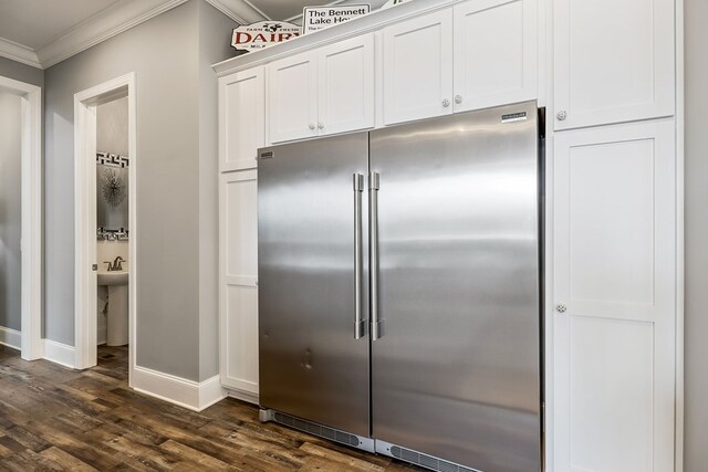 kitchen featuring dark wood-style floors, high end refrigerator, ornamental molding, white cabinetry, and baseboards