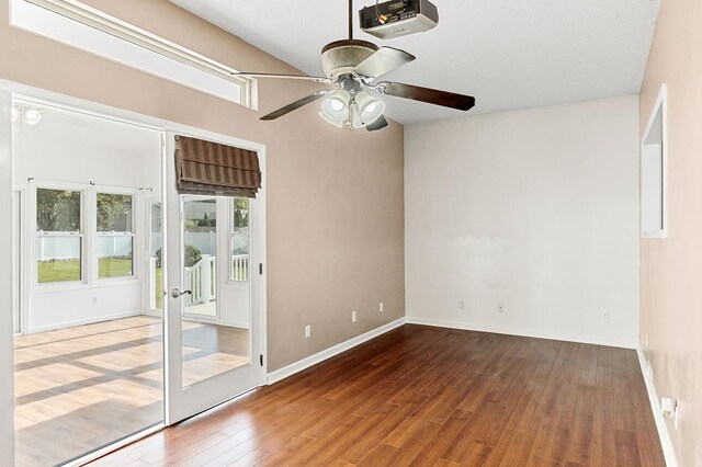 unfurnished room with a ceiling fan, french doors, baseboards, and wood finished floors