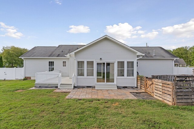 back of property featuring entry steps, a lawn, a fenced backyard, a deck, and a patio area