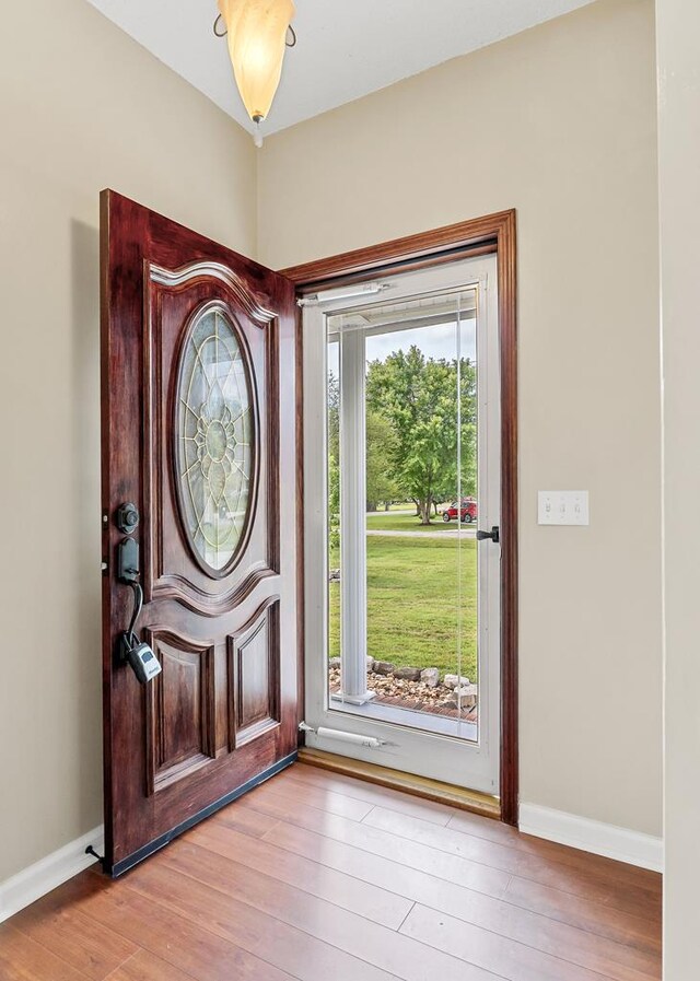 foyer with light wood-type flooring and baseboards