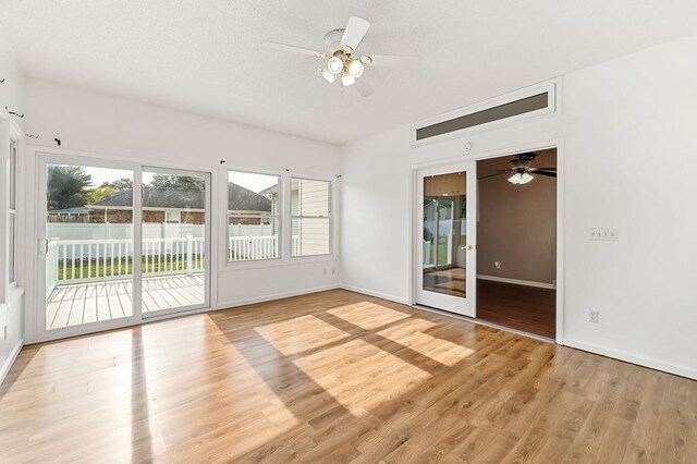 unfurnished room featuring light wood-type flooring, ceiling fan, and baseboards