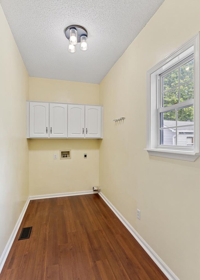 laundry area with cabinet space, baseboards, visible vents, hookup for a washing machine, and hookup for an electric dryer