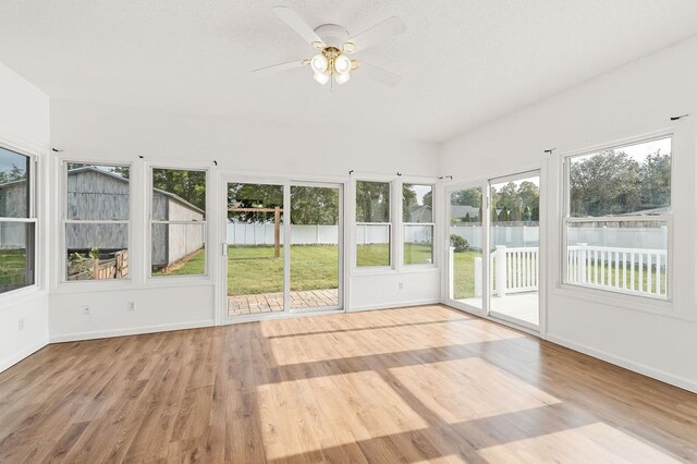 unfurnished sunroom with ceiling fan