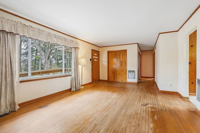 unfurnished living room featuring heating unit, baseboards, wood finished floors, and ornamental molding