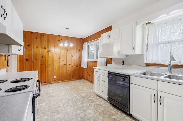 kitchen featuring dishwasher, light countertops, wood walls, white cabinetry, and a sink