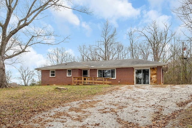 ranch-style house featuring brick siding and a wooden deck