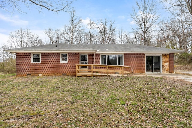 back of house featuring a wooden deck, roof with shingles, crawl space, a yard, and brick siding