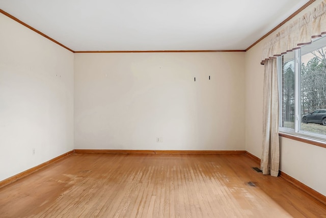 unfurnished room with light wood-type flooring, baseboards, and crown molding