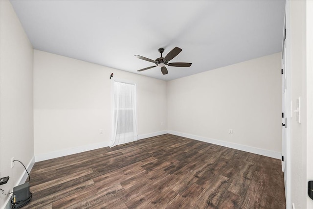 spare room featuring a ceiling fan, baseboards, and dark wood-style flooring