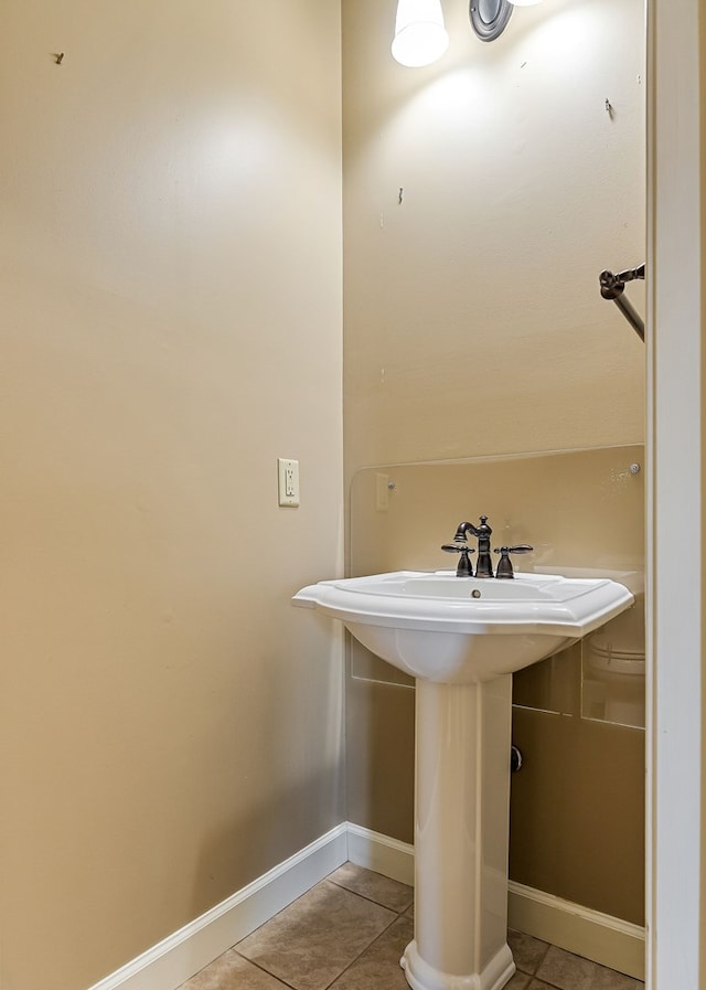 bathroom with a sink, baseboards, and tile patterned floors