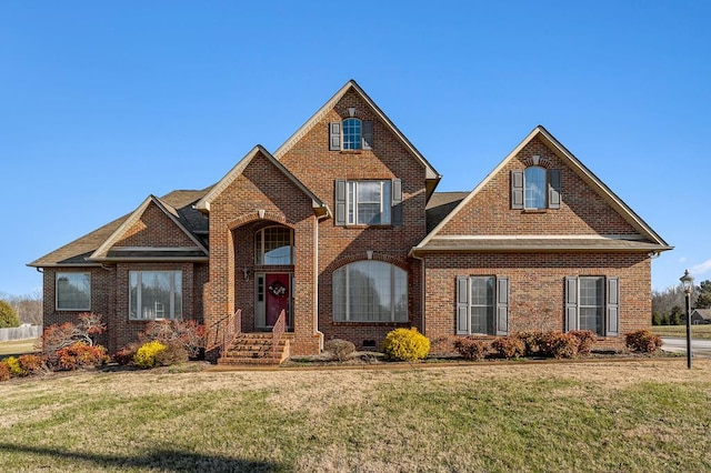 traditional-style house featuring a front lawn and brick siding