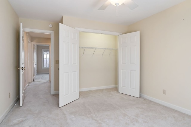 unfurnished bedroom featuring baseboards, a closet, and light colored carpet