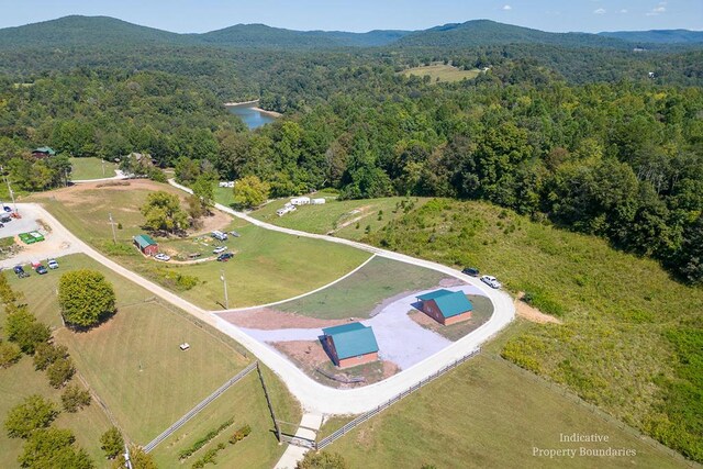 aerial view featuring a wooded view and a water and mountain view