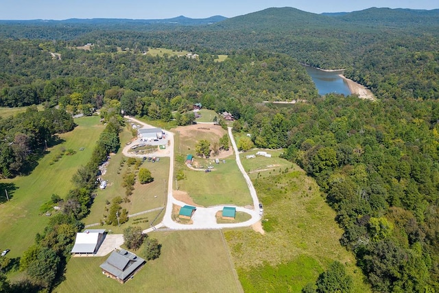 birds eye view of property featuring a wooded view and a water and mountain view