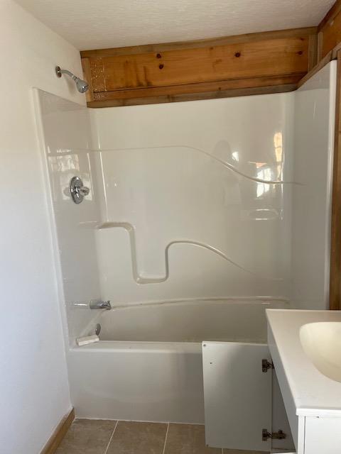 full bath featuring tile patterned flooring, shower / bathing tub combination, and vanity