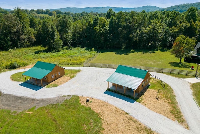 birds eye view of property featuring a rural view, a mountain view, and a view of trees