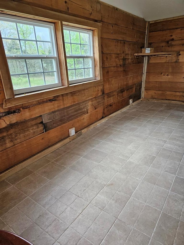 unfurnished room featuring wood walls