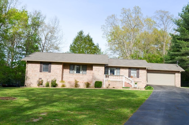 ranch-style house featuring a garage, a front lawn, and brick siding