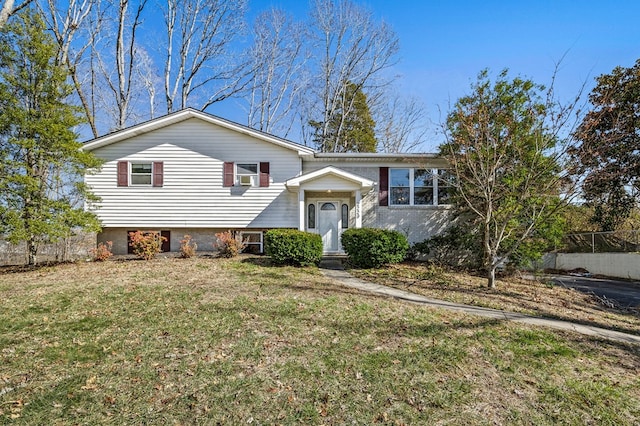 view of front of property featuring a front yard, brick siding, and fence