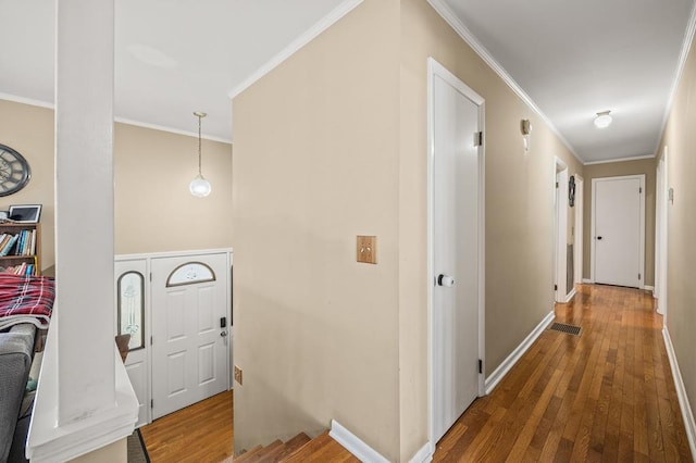 hallway with ornamental molding, baseboards, and hardwood / wood-style flooring