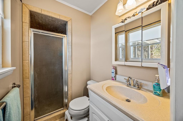 bathroom with crown molding, a shower stall, toilet, and vanity