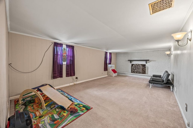 recreation room featuring carpet, visible vents, ornamental molding, a brick fireplace, and baseboards