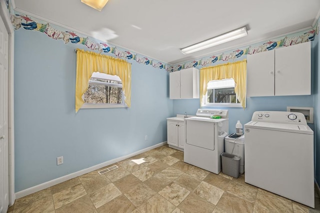 laundry room featuring a sink, visible vents, baseboards, washer and dryer, and cabinet space