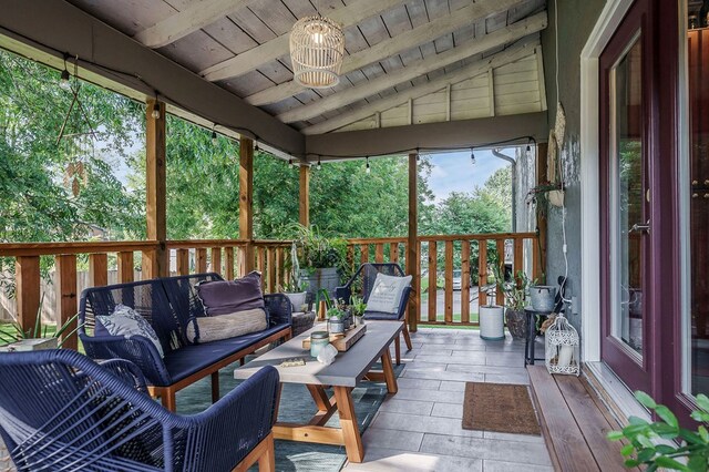 sunroom / solarium featuring vaulted ceiling with beams and wood ceiling