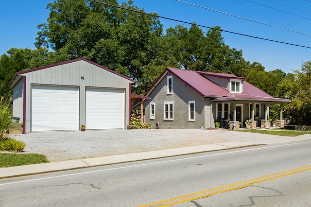 view of front of house featuring a garage, covered porch, and metal roof