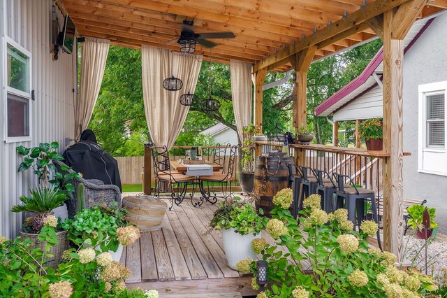 wooden deck featuring outdoor dining space and ceiling fan