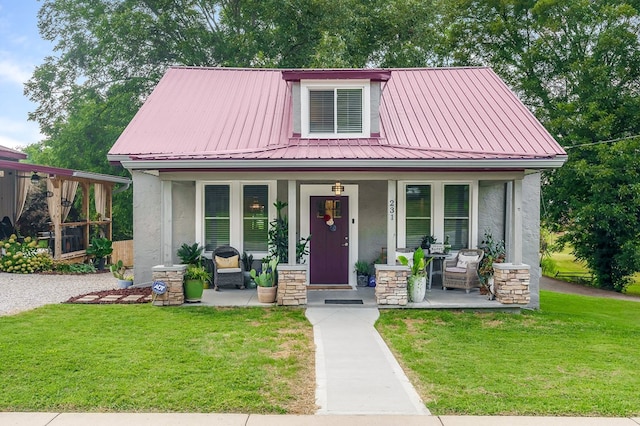 view of front of house featuring a porch, a front yard, and stucco siding