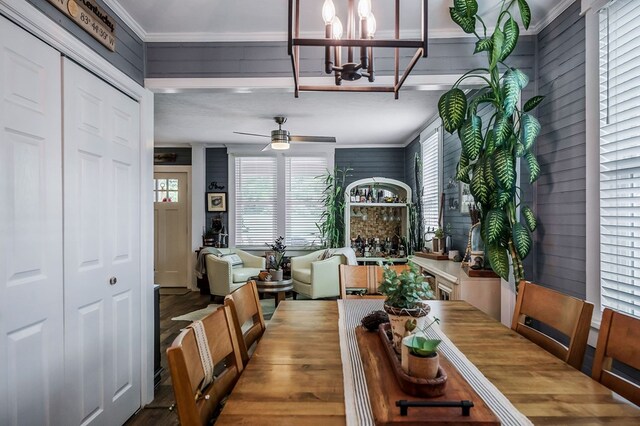 dining space featuring crown molding and ceiling fan with notable chandelier