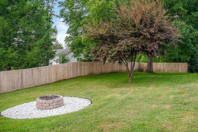 view of yard featuring a fire pit and fence