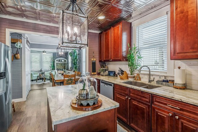 kitchen with an ornate ceiling, light stone countertops, stainless steel appliances, dark brown cabinets, and a sink