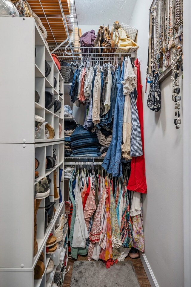 walk in closet with wood finished floors