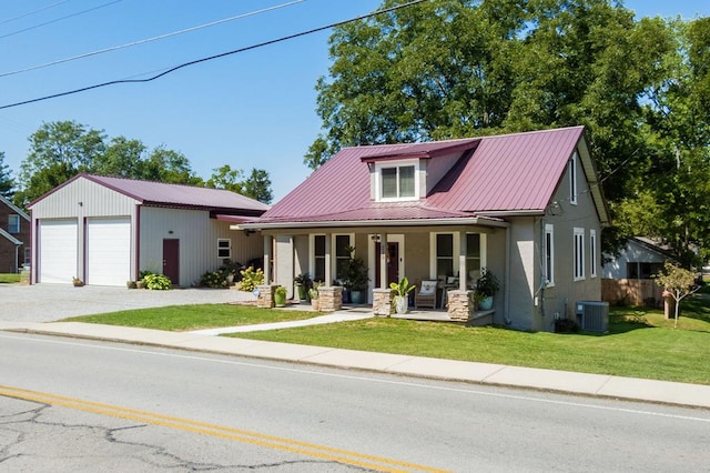 view of front facade with a porch, central AC unit, metal roof, a garage, and a front lawn