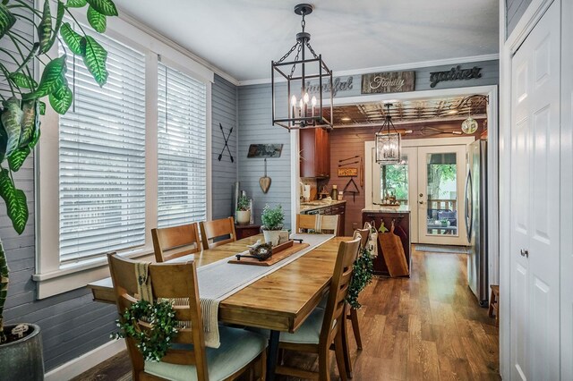 dining space with ornamental molding, french doors, plenty of natural light, and wood finished floors