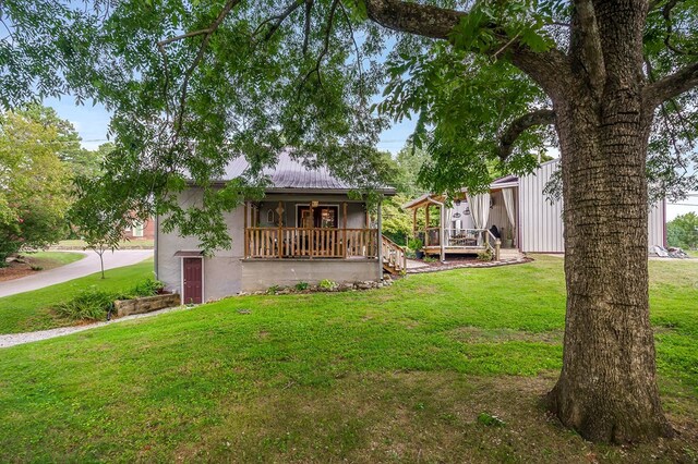 view of front of house with a wooden deck, a front lawn, and stucco siding