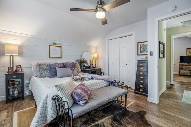 bedroom featuring lofted ceiling, a closet, visible vents, and dark wood-style flooring